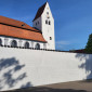 Kirche und Mauer strahlen mit dem Himmel um die Wette